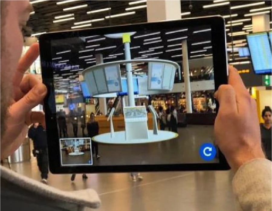 Op een tablet staat met augmented reality een nieuw ontwerp in een bestaande luchthaventerminal