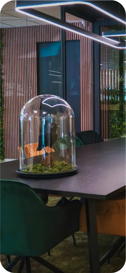 Moderne vergaderruimte van VR-Innovations met houten lamellenwand, zwarte vergadertafel en groene velvet stoelen
