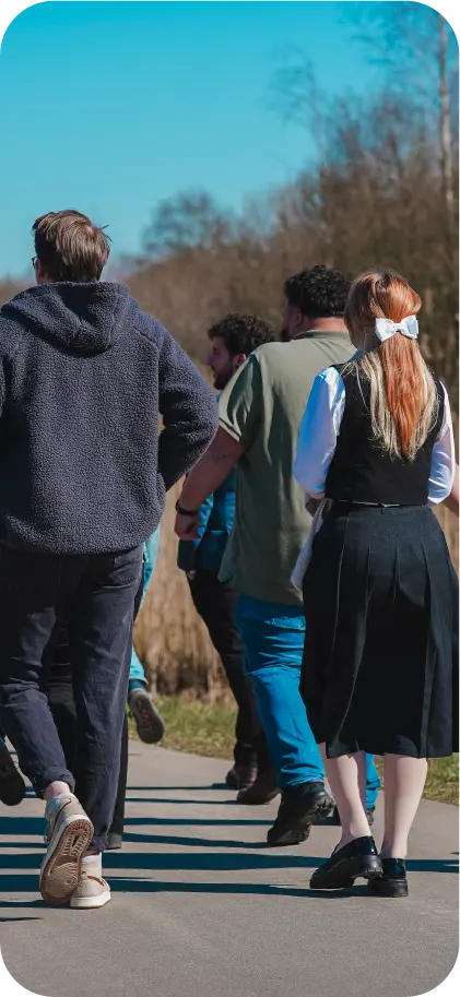 Collega's van VR-Innovations wandelen samen over een pad buiten op een zonnige dag